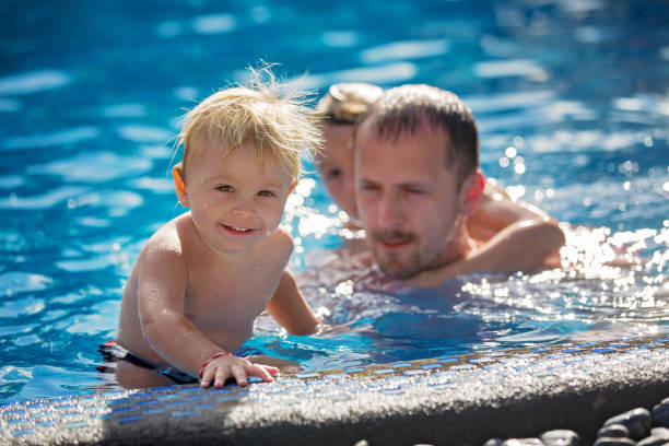 istock Happy children, brothers, having fun in the pool 1318842209