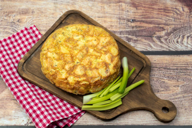 tortilla de papas fatta in casa o frittata di patate su una tavola di legno su un tavolo rustico. cibo spagnolo naturale e tipico. concetto di cucina regionale ed etnica. - tortilla de patatas foto e immagini stock