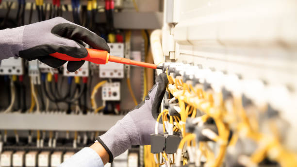 istock Electricians work to connect electric wires in the system, switchboard, electrical system in Control cabinet. 1318845392