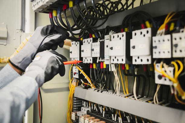 istock Electrical engineers test electrical installations and wiring on protective relays, measuring them with a multimeter. 1318845395