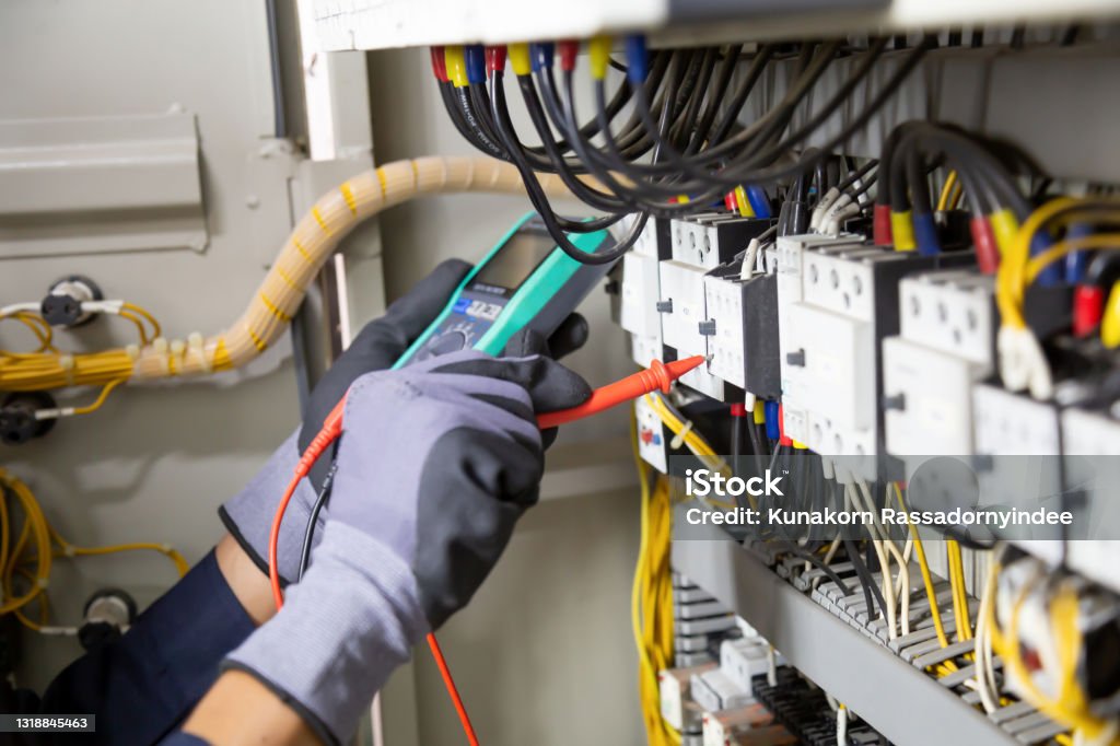 Electrician engineer tests electrical installations and wires on relay protection system. Electrician engineer tests electrical installations and wires on relay protection system. Adjustment of scheme of automation and control of electrical equipment. Electrician Stock Photo