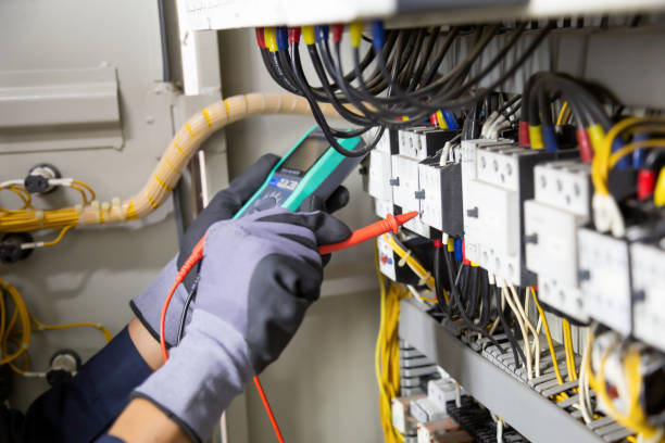 Electrician engineer tests electrical installations and wires on relay protection system. Electrician engineer tests electrical installations and wires on relay protection system. Adjustment of scheme of automation and control of electrical equipment. electrician stock pictures, royalty-free photos & images
