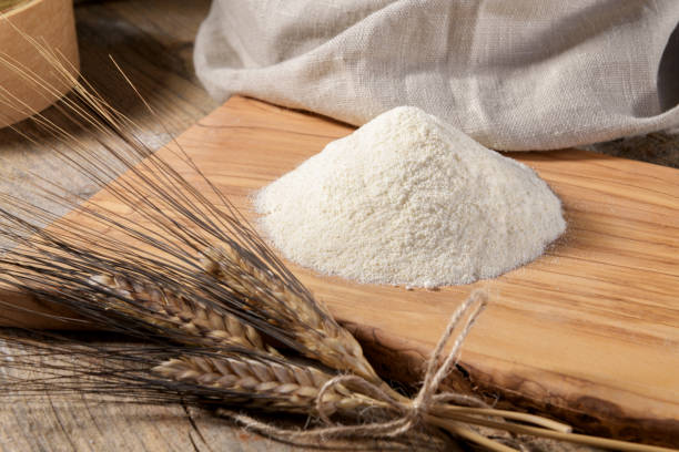 istock Wheat flour on a wooden cutboard and spikelets 1318848615