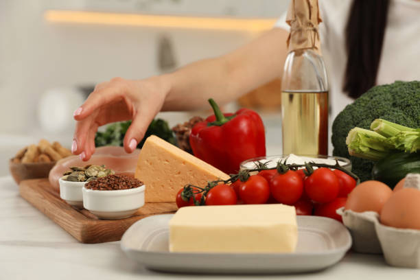 istock Woman with different products at table, closeup. Keto diet 1318849077