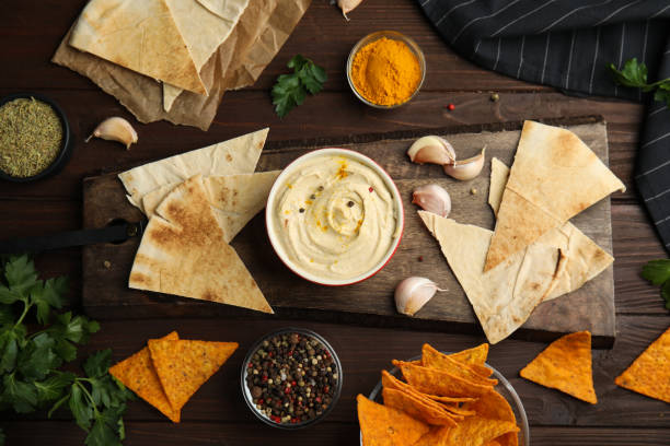 istock Flat lay composition with delicious hummus and pita chips on wooden table 1318850121