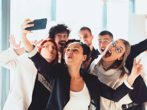 istock Happy laughing team diverse colleagues posing for selfie portrait in office, friendly group of corporate employees of different age and ethnicities making videocall looking at camera bonding together 1318850152