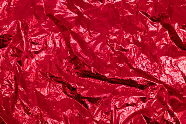 istock Wrinkled crumpled red metallic foil texture, abstract background 1318850234