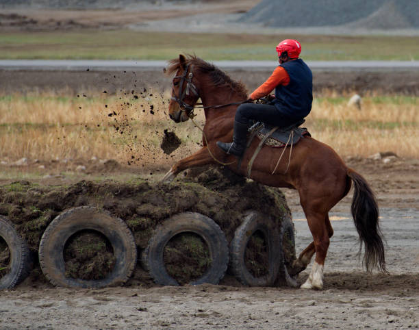 Kupchegen. Russia. May 14, 2021. Altai National Equestrian Game Kok-Boru Championship. The player of the team on the horse attacks the game gate (cauldron) in the form of a huge ring of earth.