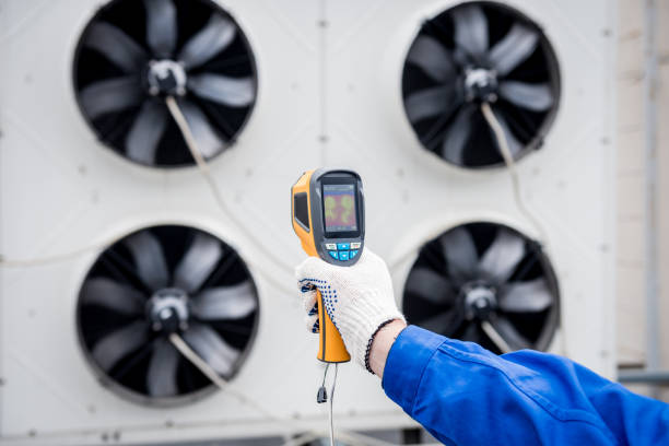 istock Technician uses a thermal imaging infrared thermometer to check the condensing unit heat exchanger. 1318852759