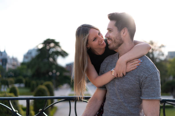 hermosa pareja abrazando en el parque y posando - heterosexual couple fotografías e imágenes de stock