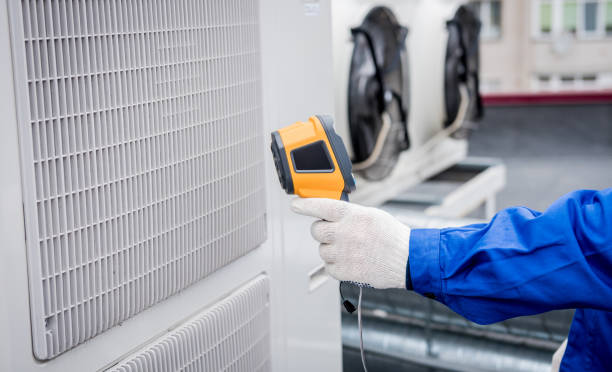 Technician uses a thermal imaging infrared thermometer to check the condensing unit heat exchanger.
