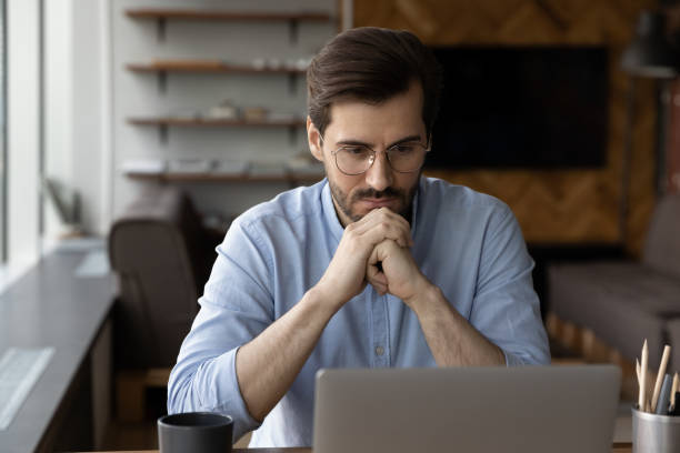 istock Pensive businessman work on laptop making decision 1318858216
