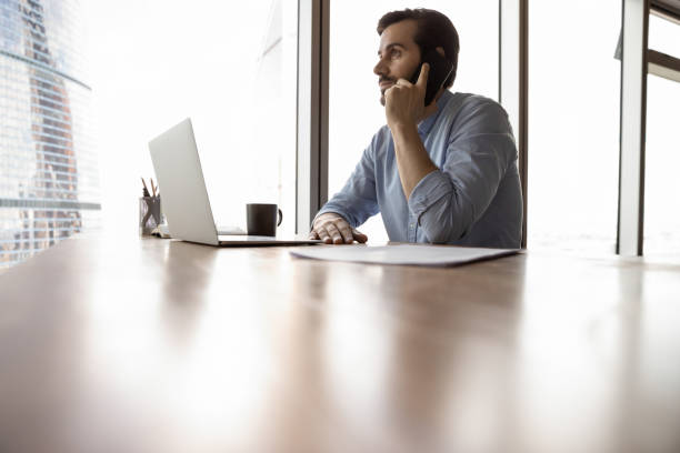 istock Successful young businessman talk on cellphone in office 1318858223