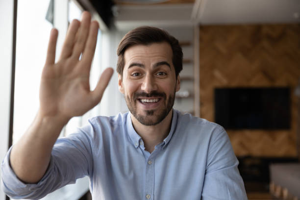 istock Portrait of smiling man wave talking on video call 1318858228