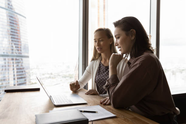 istock Motivated women work on computer in office together 1318858246