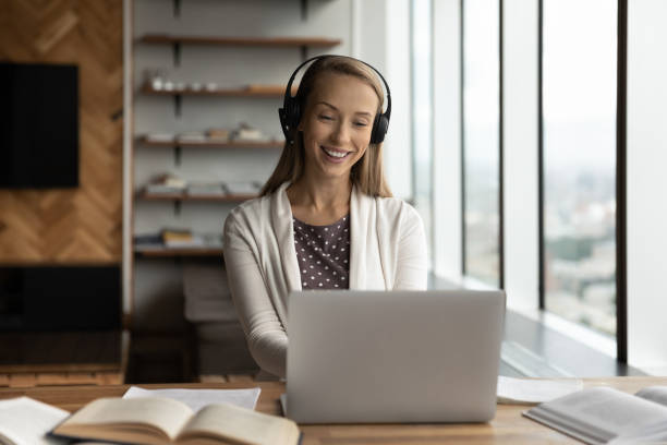 istock Happy woman in headphones study online on computer 1318858281