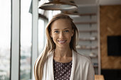 Headshot portrait of smiling female employee posing in office