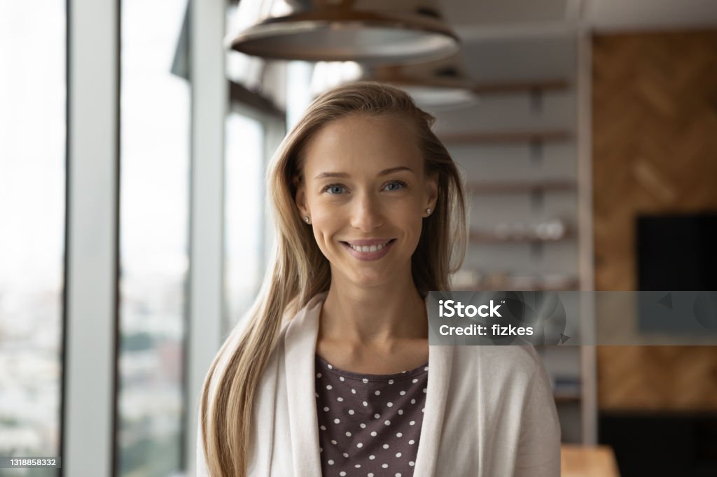 Headshot portrait of smiling female employee posing in office Headshot portrait of smiling young Caucasian woman employee or worker pose in modern office. Profile close up picture of happy successful confident businesswoman show leadership. Employment concept. Profile View Stock Photo