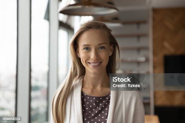 Headshot Portrait Of Smiling Female Employee Posing In Office Stock Photo - Download Image Now