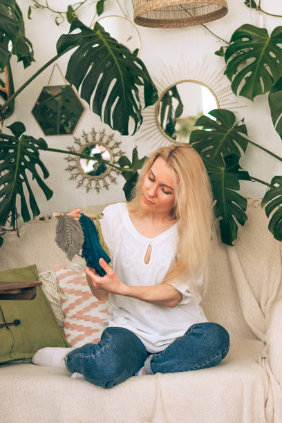 istock A young blonde woman weaving macrame in a home workshop.Handmade concept. 1318858515
