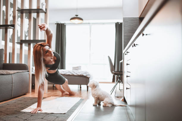 istock Side Plank Exercise By Beautiful Female Working Out With Puppy At Home 1318858516