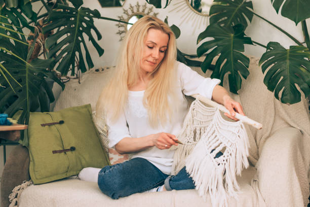 istock A young blonde woman weaving macrame in a home workshop.Handmade concept. 1318858525