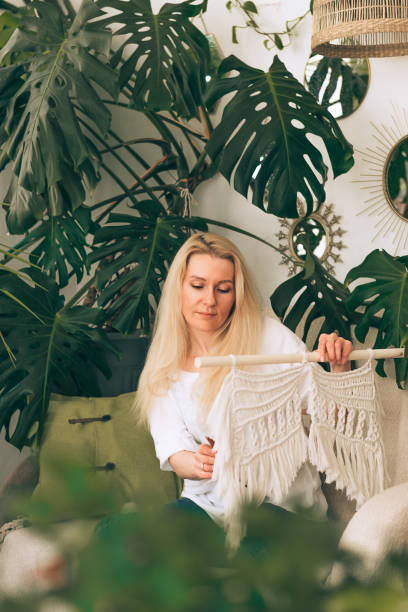 istock A young blonde woman weaving macrame in a home workshop.Handmade concept. 1318858620