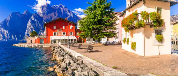 Photo of Beautiful lake  Lago di Grada. Panoramic view of Torbole village with colorful houses . Italy, Trento