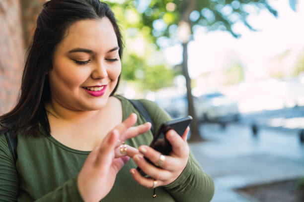 istock Young plus size woman using her mobile phone. 1318860248