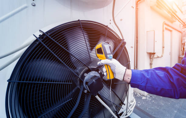 istock Technician uses a thermal imaging infrared thermometer to check the condensing unit heat exchanger. 1318864199
