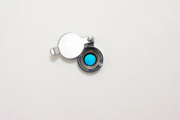 Photo of Home door peephole with metal lid cover white wood background macro close up shot