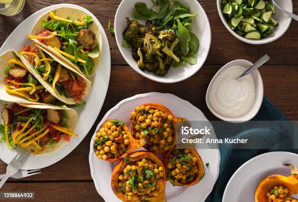 Overhead View Autumn Dinner Table With Baked Pumpkin With Chickpeas Curry Tortilla With Falafel And Salad Stock Photo - Download Image Now