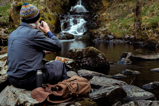 istock Senior man drinking from a thermos flask cup 1318865186