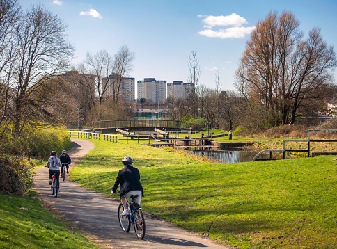 Glasgow, Scotland - Cyclists passing a series of lock gates on the Forth and Clyde Canal heading west towards Clydebank.