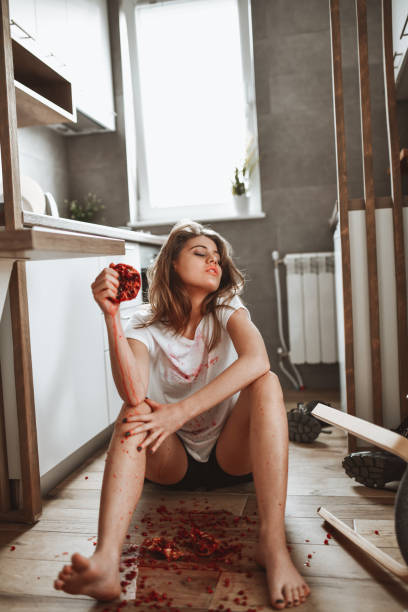 Cute Female Crushing Pomegranate In Kitchen And Getting Everything Red And Dirty