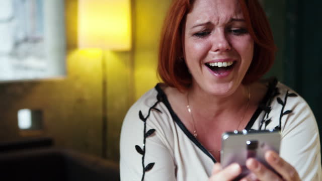 Tears of joy on the face of a woman who uses a smartphone