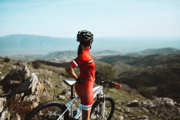 istock Female Cyclist Climbing Summit And Looking At Valley Bellow 1318870370