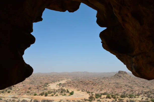 Laas Geel, Maroodi Jeex region, Somaliland, Somalia: view from under a rock overhang where prehistoric paintings are located, framing a barren desert landscape with sparse acacias, a dry wadi and a rocky hill.