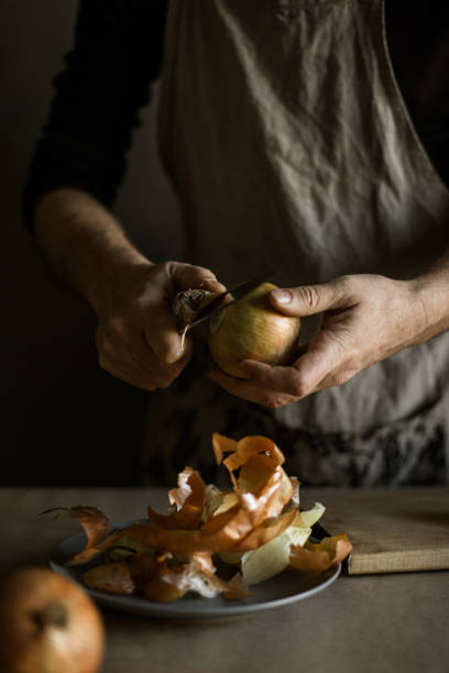 istock Male hands peeling onions 1318872436