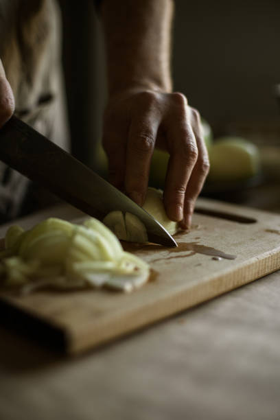istock Male hands peeling onions 1318872453