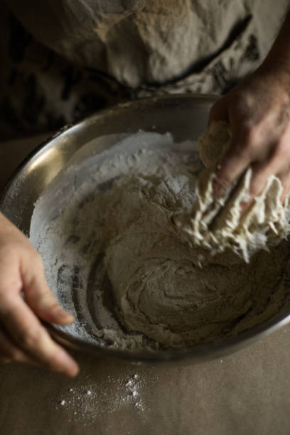 istock Male hands kneading batter in bowl 1318872481