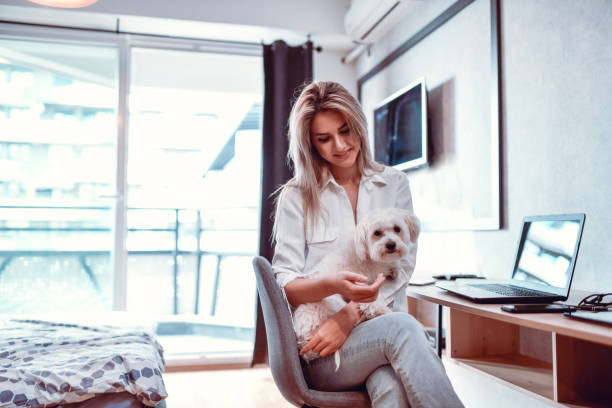 istock Female Relaxing From Work By Petting Lap Dog At Home 1318874493