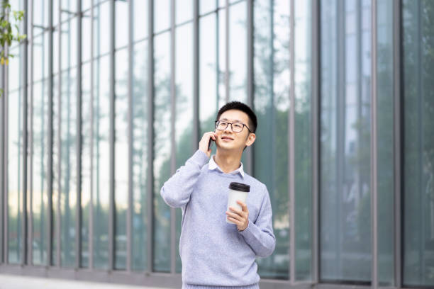 istock An Asian man using mobile phone to make a call with coffee in downtown district 1318874612