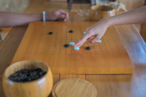 istock Women hand putting a stone on baduk (weiqi,igo)board ,ancient strategy board game 1318875186