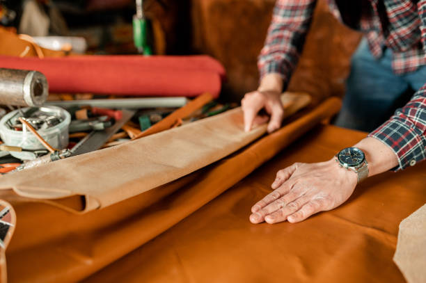 Unrecognizable man working and touching a piece of genuine leather in his workshop