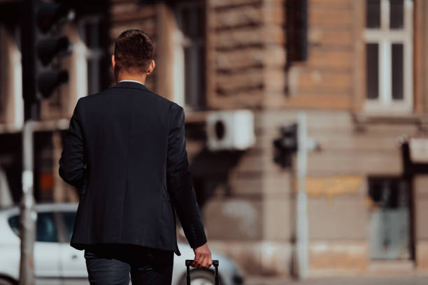 istock Businessman with suitcase walks down the street 1318875873