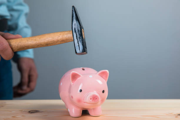 istock breaks a piggy bank with a hammer 1318876631