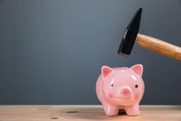 istock breaks a piggy bank with a hammer 1318876640
