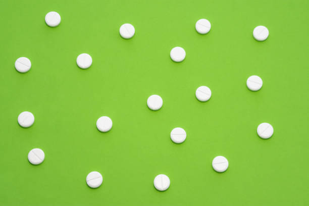 istock White tablets scattered on green background form a speckled ornament. Photo for use in medicine, pharmacy, pharmaceutical production and marketing, treatment of diseases of the gastrointestinal tract 1318877085