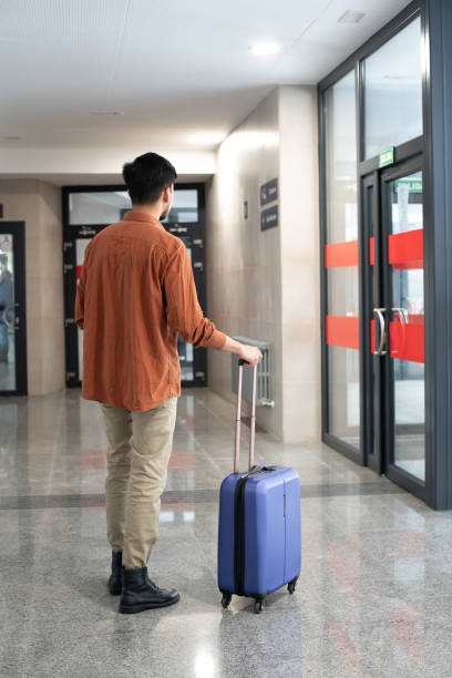 istock Latin man at the station with suitcase 1318884193